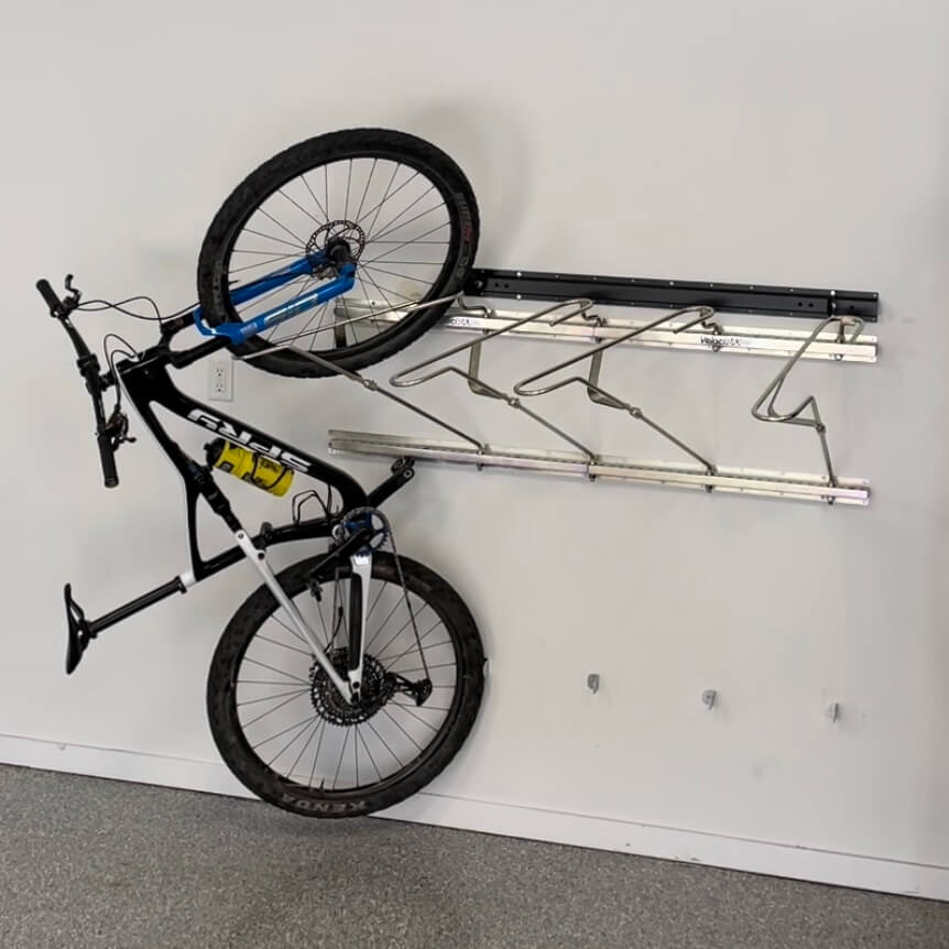 Tilt and pivot garage bike rack with a racked mountain bike.